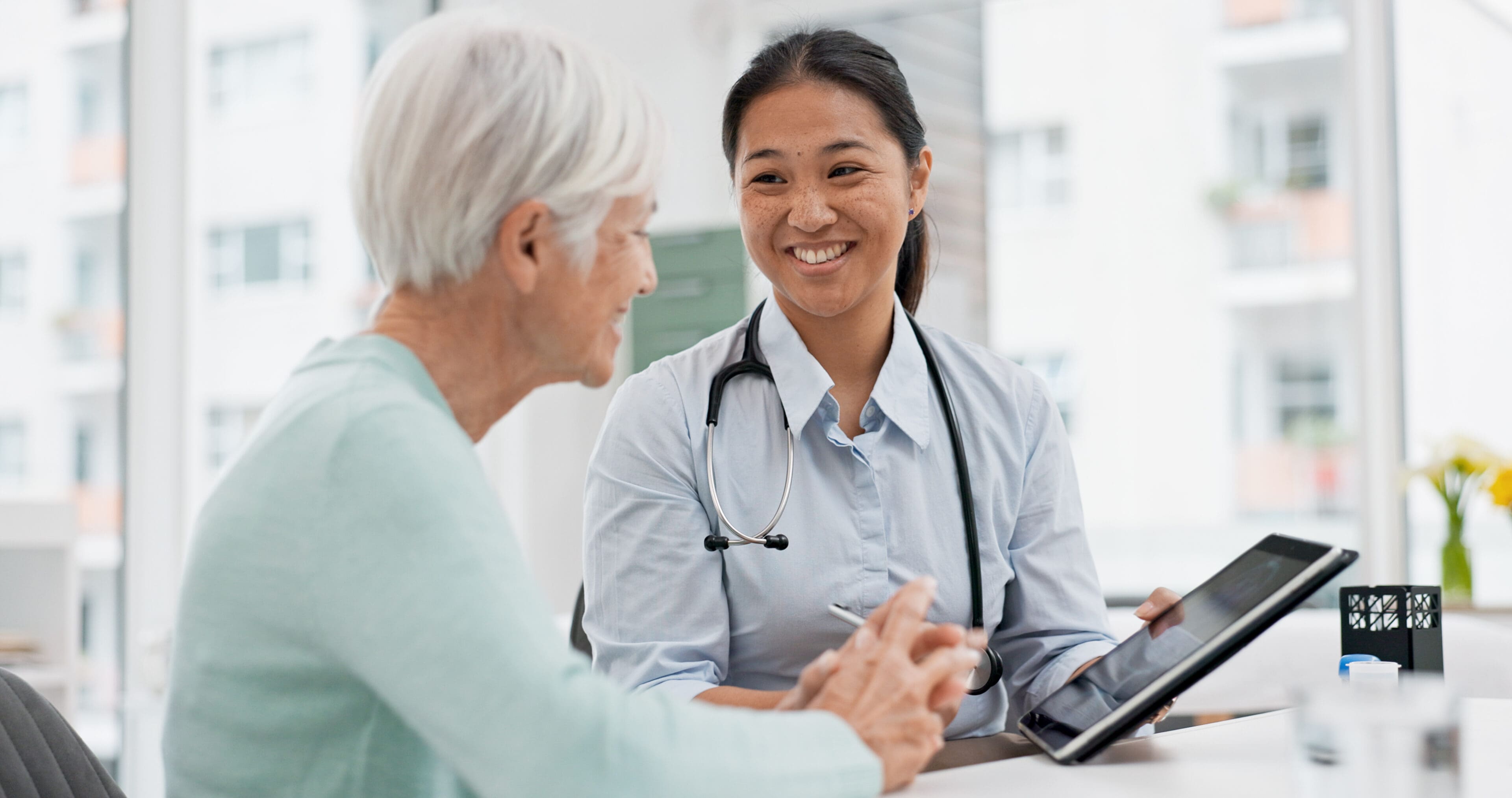 A woman in a blue shirt is talking to an older person