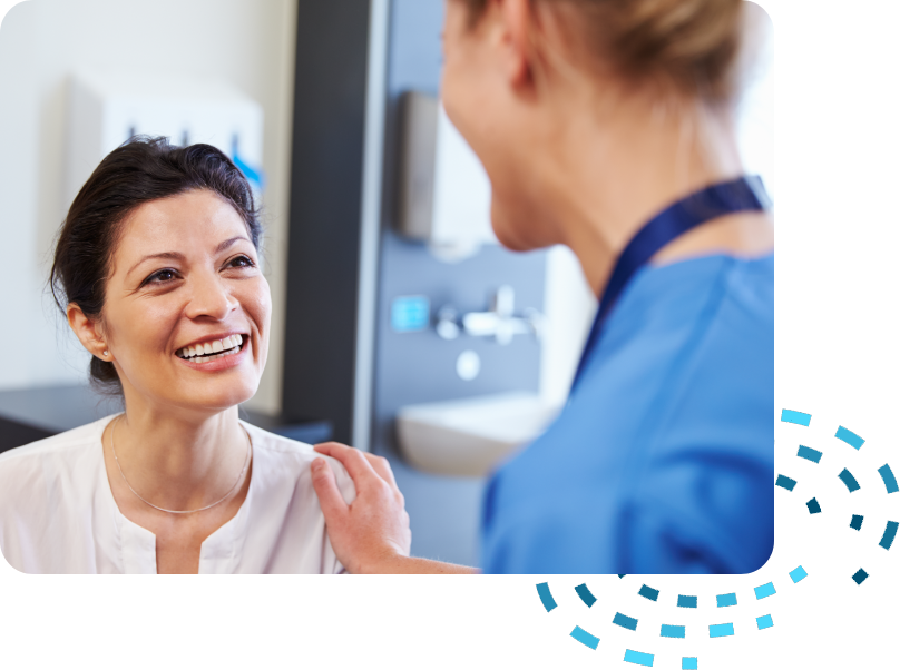 A woman talking to a nurse in an office.